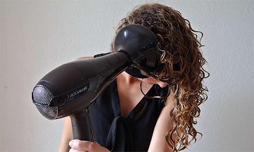 девушка сушит волосы феном с накладкой «диффузор»