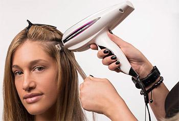 девушке наращивают волосы лазерным аппаратом