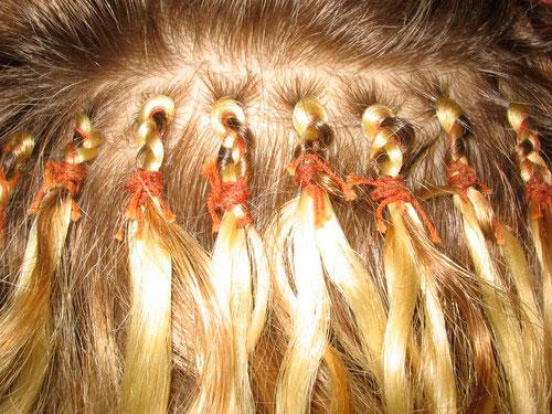 наращенные на косички волосы, обвязанные ниткой по бразильской технологии