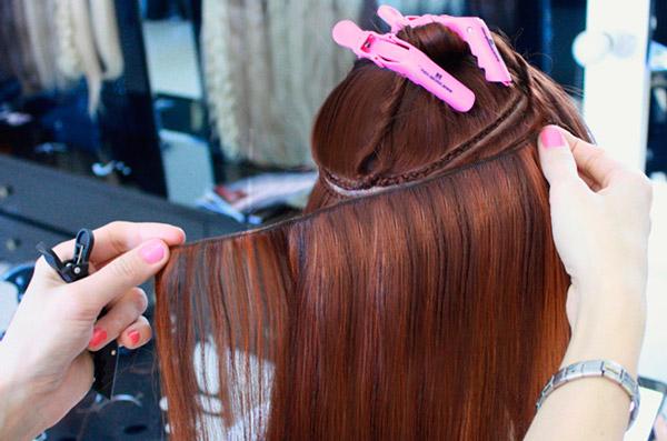 девушке наращивают волосы пришиванием тресса